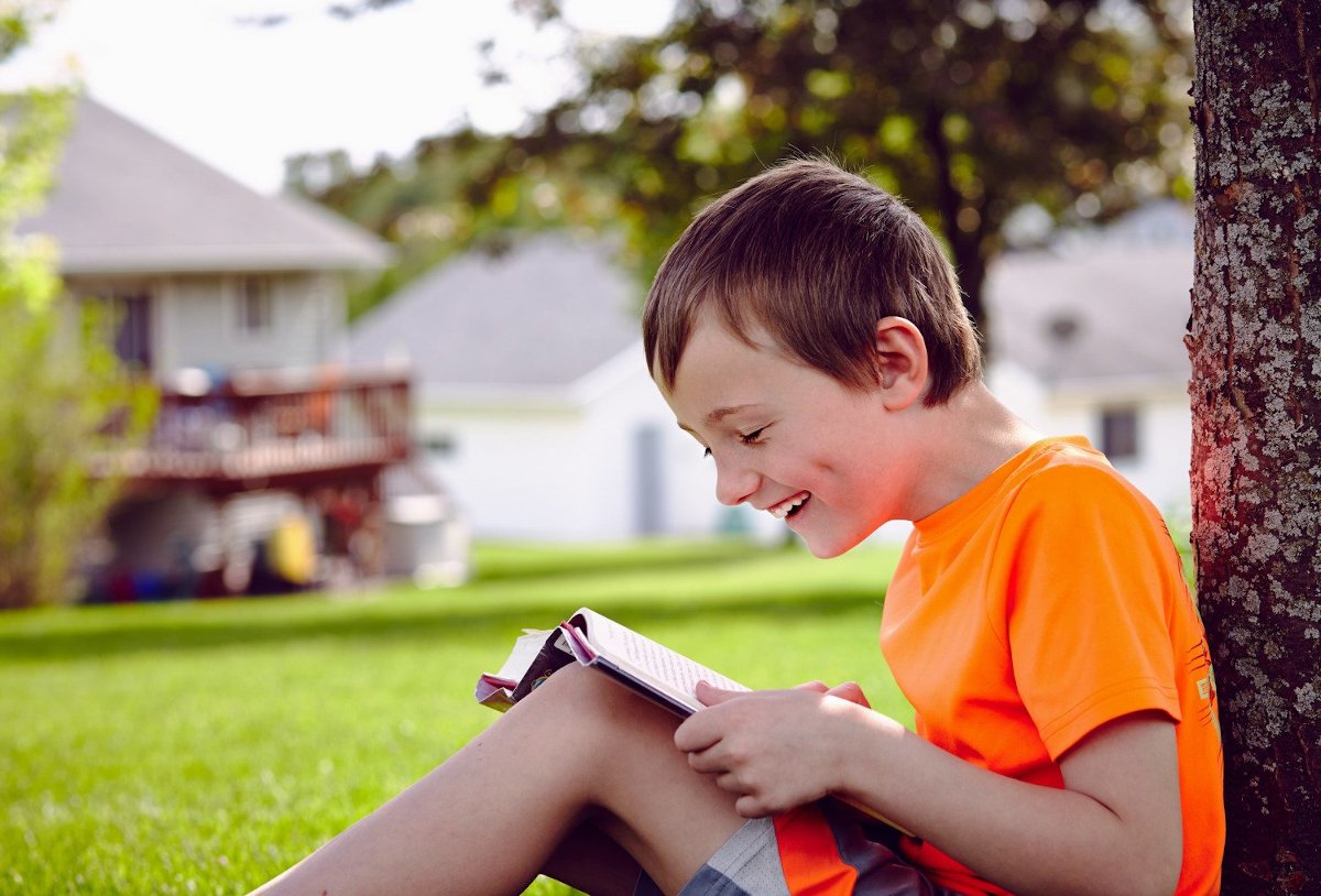 Boy under tree reading