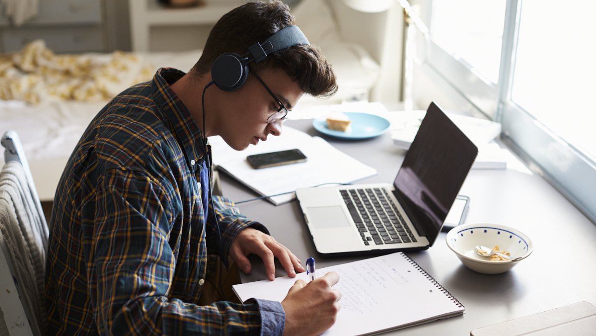 high school boy studying with headphones